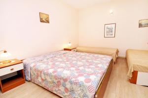 - une petite chambre avec un lit et une table de nuit dans l'établissement Apartments by the sea Brgulje, Molat - 6241, à Brgulje