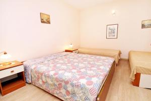 ein kleines Schlafzimmer mit einem Bett und einem Nachttisch in der Unterkunft Apartments by the sea Brgulje, Molat - 6241 in Brgulje