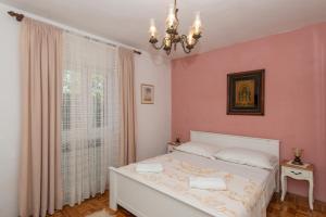 a bedroom with a white bed and a window at Apartments with a parking space Molat - 6249 in Molat