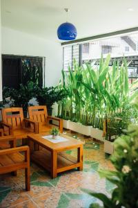 Habitación con mesas de madera, sillas y plantas. en Nu Phen Homestay en Chiang Mai