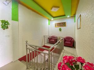 ein Zimmer mit einer Treppe mit roten Stühlen und Blumen in der Unterkunft Hotel Karunia 2 Jailolo in Porniti