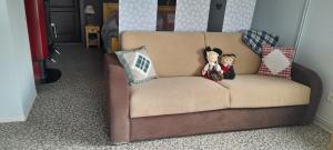 un sofá con dos animales de peluche sentados en él en Le petit paradis de Sylvala, en Bourg-Bruche