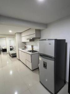 a kitchen with a refrigerator and a stove at Lugar acogedor y muy central en Medellin in Medellín