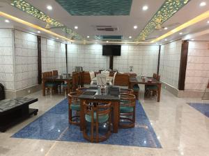 a dining room with tables and chairs and a tv at MR River Resort in Rishīkesh