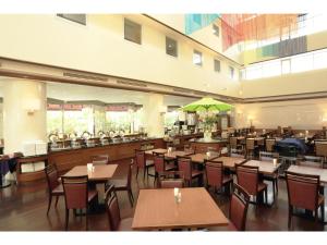 ein Restaurant mit Tischen und Stühlen und einem grünen Sonnenschirm in der Unterkunft Smile Hotel Naha City Resort in Naha