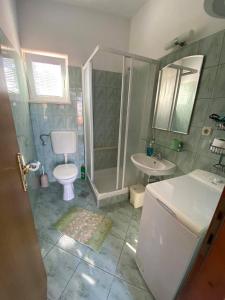 ein Bad mit einer Dusche, einem WC und einem Waschbecken in der Unterkunft Apartments by the sea Postira, Brac - 14902 in Postira