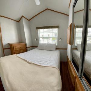 a small bedroom with a bed and two windows at Ocean Grove RV Resort St Augustine in St. Augustine