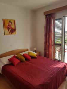 Un dormitorio con una cama con sábanas rojas y una ventana en Apartments with a parking space Orebic, Peljesac - 4494 en Orebić
