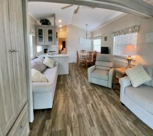 a living room with two white couches and a kitchen at Ocean Grove RV Resort St Augustine in Saint Augustine