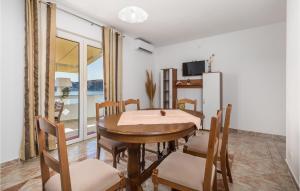 een eetkamer met een tafel en stoelen en een raam bij 2 Bedroom Beautiful Apartment In Stara Novalja in Stara Novalja