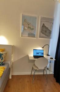 a bedroom with a desk with a laptop computer on a chair at The Cherry Apartment - 'Den Gule Svane' Guest House near Rønne & Beach in Rønne