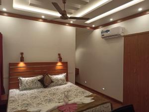Marari Xavier's Inn في أليبي: غرفة نوم بسرير ومروحة سقف