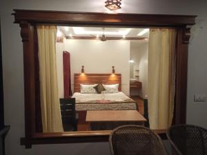 1 dormitorio con cama y espejo grande en Marari Xavier's Inn en Alleppey