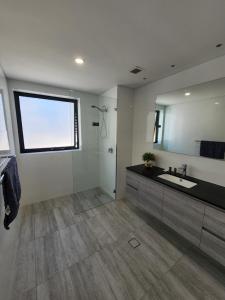 a bathroom with a sink and a large mirror at PERTH CBD APARTMENTS in Perth