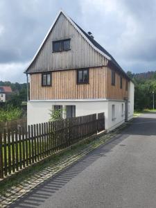 ein großes Haus mit einem Zaun davor in der Unterkunft Mika's Haus in Luftkurort Lückendorf