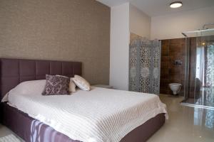 a bedroom with a large bed and a shower at Sea-view Apartment in Marsalforn in Marsalforn