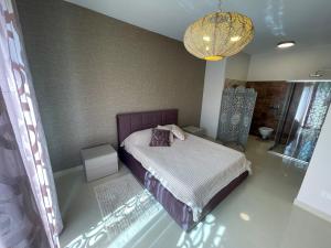 sypialnia z łóżkiem i żyrandolem w obiekcie Sea-view Apartment in Marsalforn w mieście Marsalforn