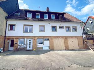een groot wit huis met twee garagedeuren bij Ferienwohnung im Harz- Altenau! in Altenau