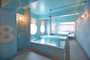 ein großes Bad mit einer Badewanne und einem Fenster in der Unterkunft 8 Hotel Shonan Fujisawa in Fujisawa
