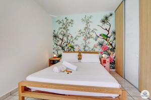 a bedroom with a bed with a floral wall at T2 classé 3 étoiles - Le Léopardi - À 2 pas du lagon de La Saline-les-Bains in La Saline les Bains