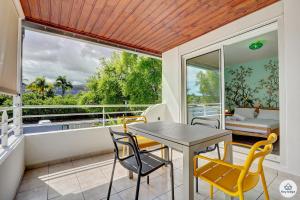 a dining room with a table and chairs and a large window at T2 classé 3 étoiles - Le Léopardi - À 2 pas du lagon de La Saline-les-Bains in La Saline les Bains
