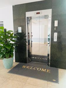 una alfombra de bienvenida frente a una puerta con una señal de bienvenida en Hoang Ngan 1 Hotel - TP. Vinh, en Vinh