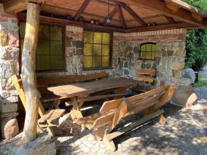 a wooden table and chairs in front of a stone building at Główna Apartamenty Nad Nogatem in Malbork