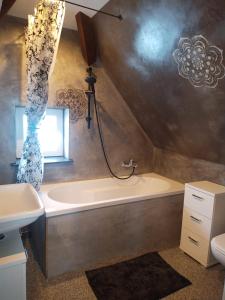 a bathroom with a bath tub and a sink at Zum Aufstieg in Ohlsbach