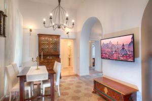 uma sala de jantar com uma mesa e um lustre em Romance al Colosseo em Roma