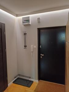 a hallway with a black door and a cross on the wall at Apartament Sucharskiego in Gdynia