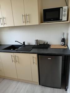 a kitchen with a sink and a microwave at Apartament Sucharskiego in Gdynia