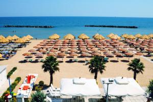 a beach with lots of umbrellas and the ocean at FRANGI HOUSE in Pescara