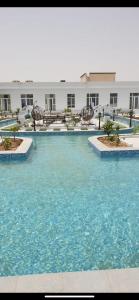 una gran piscina de agua azul en un hotel en VENESIA chalet, en Al Kāmil