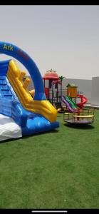 einen Spielplatz mit einer blauen und gelben Wasserrutsche in der Unterkunft VENESIA chalet in Al Kāmil
