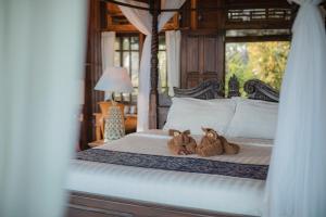 two teddy bears sitting on a bed in a bedroom at Secret Moon Beach House in Jasri