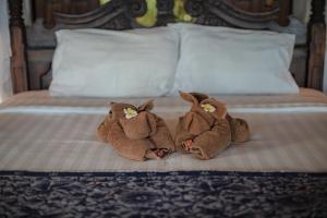 two stuffed animals are sitting on a bed at Secret Moon Beach House in Jasri