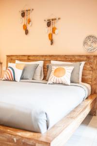 a wooden bed with pillows on it in a room at THE SPARE ROOM BALI in Canggu