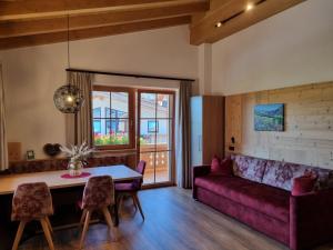 salon z fioletową kanapą i stołem w obiekcie Greidlhof Alpstyle Apartments w mieście Fügen +37 zdjęć