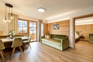 salon z kanapą i stołem w obiekcie Greidlhof Alpstyle Apartments w mieście Fügen