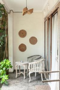 a porch with two chairs and a table and a ceiling at THE SPARE ROOM BALI in Canggu