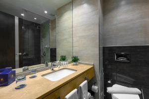 فندق سولاف لكجري في عمّان: حمام مع حوض ومرآة