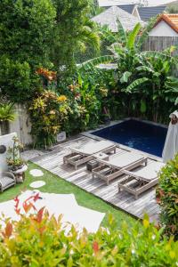 a swimming pool in the middle of a yard at THE SPARE ROOM BALI in Canggu