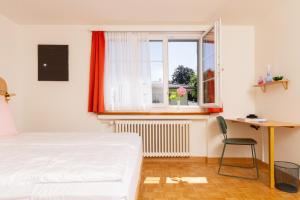 a bedroom with a bed and a desk and a window at Villa Maria in Lucerne +15 photos