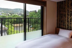 a bedroom with a bed and a large window at Rinn Gion Kenninji in Kyoto