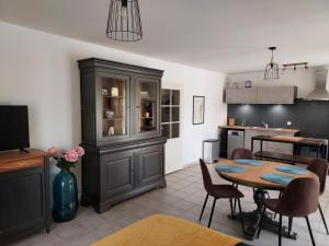 a living room with a table and a kitchen at Georges, un appartement au look chic rustique in Saint-Georges-sur-Baulche