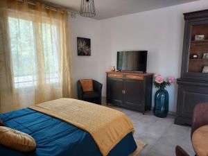 een slaapkamer met een bed en een flatscreen-tv bij Georges, un appartement au look chic rustique in Saint-Georges-sur-Baulche
