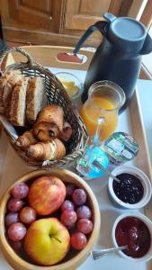 a table with a basket of bread and a bowl of fruit at Le Studio du Crot Noir in Cussy-en-Morvan