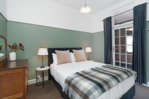 a bedroom with a large bed and a window at Bundanoon Hotel in Bundanoon