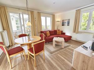 a living room with a red couch and a table at Wohnpark Stadt Hamburg - Apt. 04 in Binz