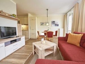 a living room with a red couch and a table at Wohnpark Stadt Hamburg - Apt. 04 in Binz